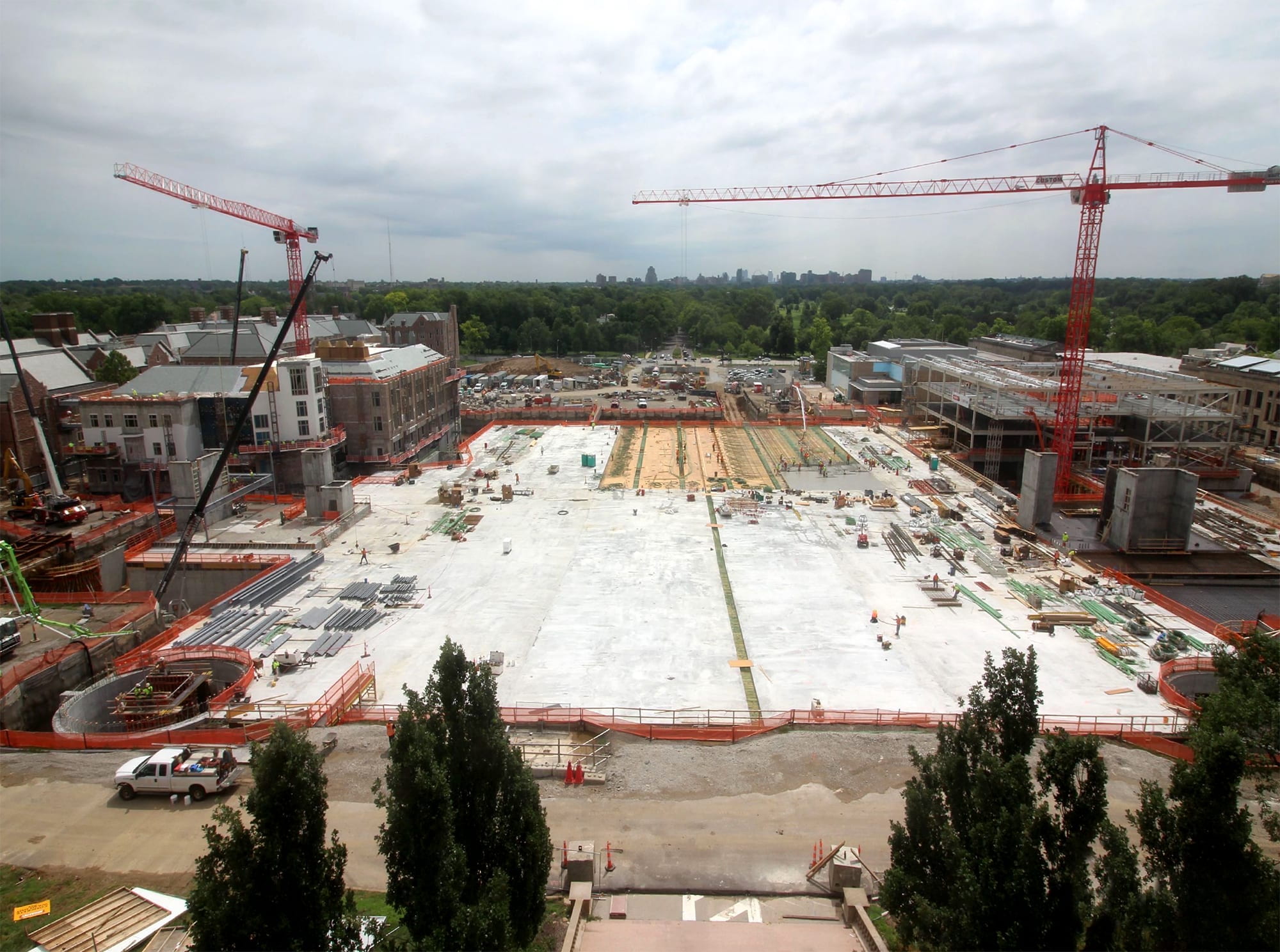 large expanse of concrete on a construction site with red cranes