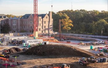 Mound of dirt being used for backfill around the site with McKelvey Hall construction in the background