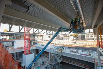 A worker insulates ductwork on the Weil Hall cantilever