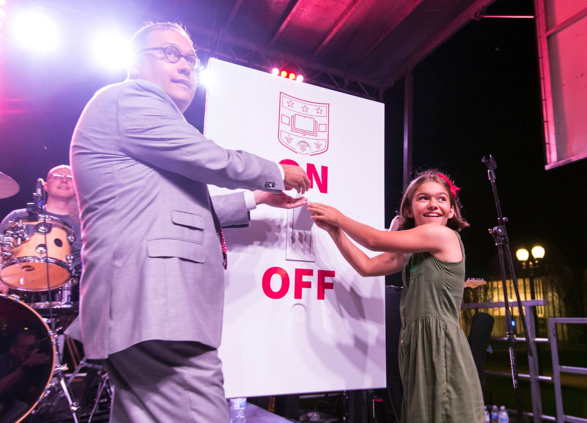 WashU Chancellor Andrew D. Martin and his daughter Olive flip a big switch during Convocation events